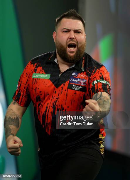 Michael Smith of England celebrates winning his second round match against Kevin Doets of the Netherlands on Day One of 2023/24 Paddy Power World...