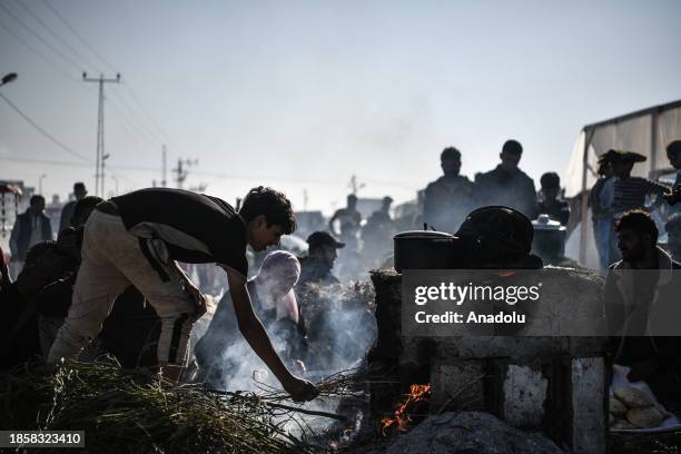 Palestinians prepare food in a clay oven they built themselves ,displaced to Southern Gaza due to Israeli attacks, in Rafah, Gaza on December 18,...