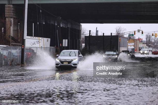 Cars pass on flooded roadways as a powerful storm causes heavy rain and strong wind with fallen trees overnight in New Jersey, United States on...