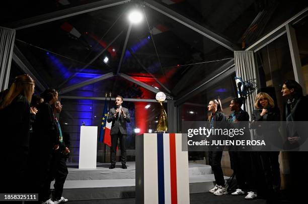 France's President Emmanuel Macron , flanked by France's first lady Brigitte Macron and French Sports Minister Amelie Oudea-Castera , delivers a...