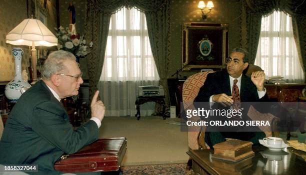 Ambassador for the American States Organization Luigi Einaudi talks with Honduran President Carlos Flores 27 April 2001 in the Government House in...