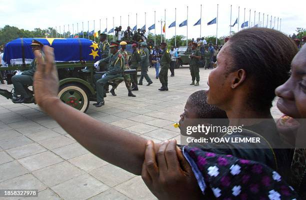 Woman waves good bye slained Democratic Republic of Congo president Laurent Kabila as the coffin makes its way to a mausoleum outisde Kinshasa's...