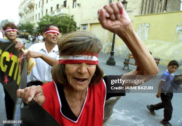 People with their eyes covered demonstrate in favor of the release of the "vladivideos" recorded by former presidential adviser Vladimiro Montesinos,...