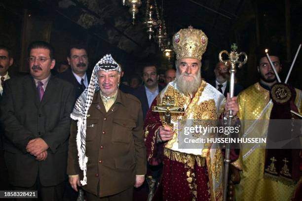 Palestinian Authority President Yasser Arafat and acting Greek Patriarch of Jerusalem Klarinos walk in the Church of the Nativity in Bethlehem late...