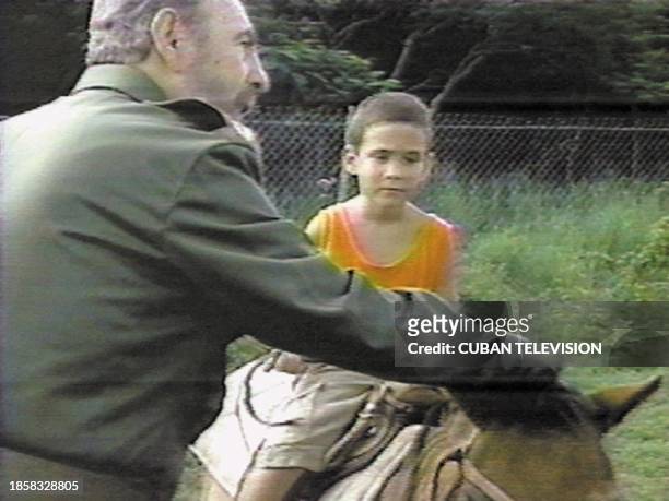 In this image taken 14 July 2000 for Cuban television and released 05 December 2000 in Havana, Cuban President Fidel Castro helps Elian Gonzalez ride...