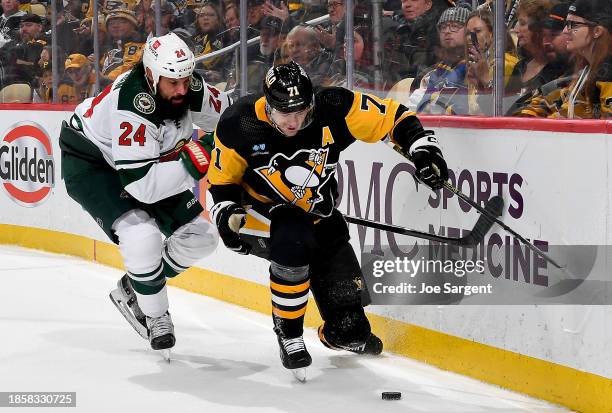 Evgeni Malkin of the Pittsburgh Penguins battles against Zach Bogosian of the Minnesota Wild at PPG PAINTS Arena on December 18, 2023 in Pittsburgh,...