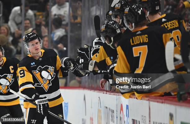 Jake Guentzel of the Pittsburgh Penguins celebrates with teammates on the bench after scoring a goal in the second period during the game against the...