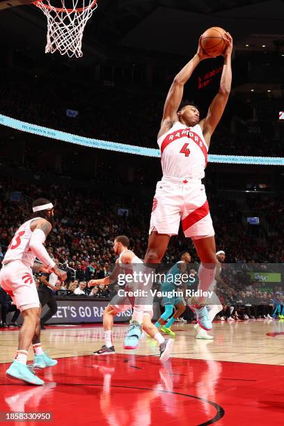 Scottie Barnes of the Toronto Raptors grabs a rebound during the game against the Charlotte Hornets on December 18, 2023 at the Scotiabank Arena in...