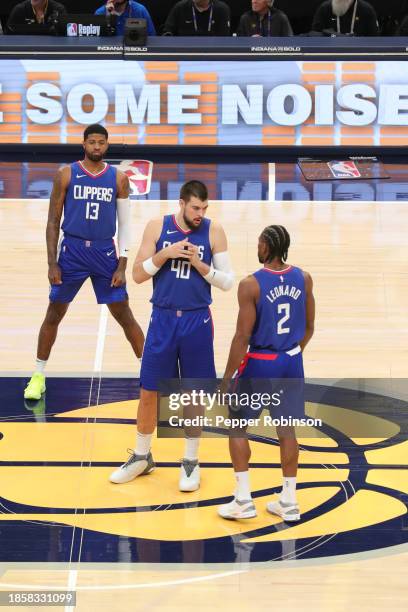 Players stand on the court before the game against the Indiana Pacers on December 18, 2023 at Gainbridge Fieldhouse in Indianapolis, Indiana. NOTE TO...