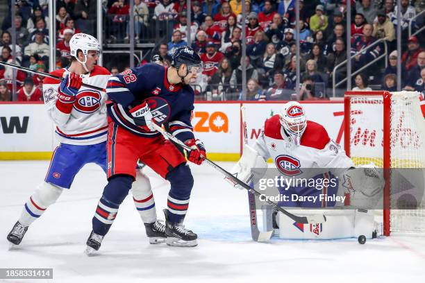 Nino Niederreiter of the Winnipeg Jets looks for a rebound as goaltender Jake Allen of the Montreal Canadiens makes a pad save during first period...