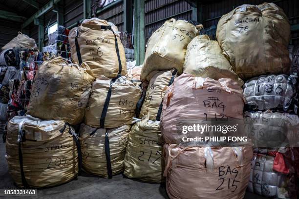 This picture taken on October 31, 2023 shows bundles of secondhand clothes at a warehouse in Inashiki city, Ibaraki Prefecture. In Japan, the world's...