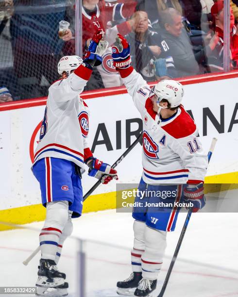 Christian Dvorak and Brendan Gallagher of the Montreal Canadiens celebrate a second period goal against the Winnipeg Jets at the Canada Life Centre...
