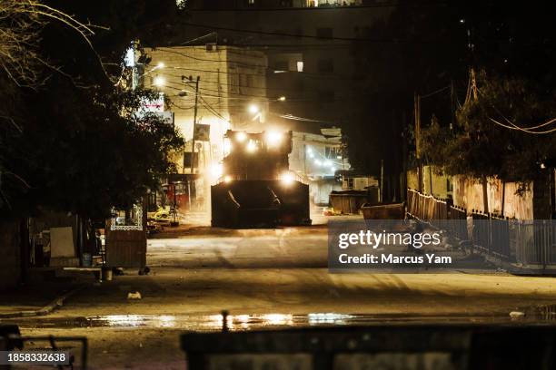 An Israeli military bulldozer clears the road as road make its way down Al Mahata street as Israeli security forces conduct raid operations...