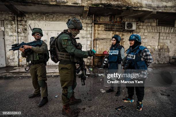 Israeli soldiers stop an inspect identification for photojournalists Raneen Sawafta and Shatha Hanaysha covering the news as Israeli forces conduct...