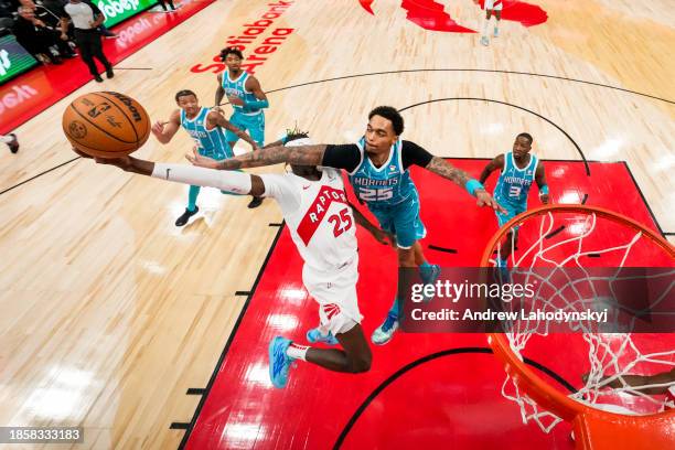 Chris Boucher of the Toronto Raptors is fouled by P.J. Washington of the Charlotte Hornets while driving to the basket during second half NBA action...