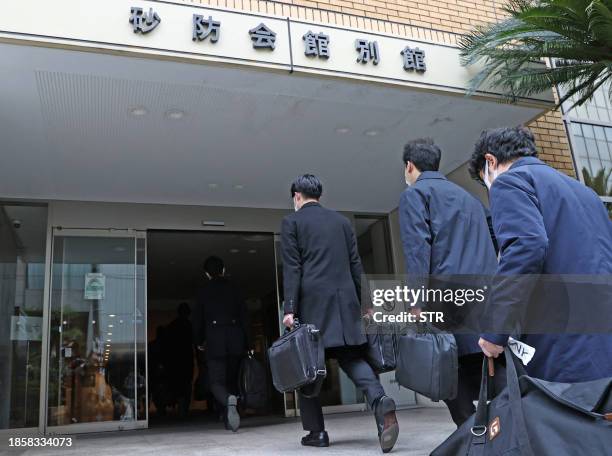 Officials from the Tokyo District Public Prosecutors Office enter a building to search the office of Shisuikai, a faction of the Liberal Democratic...