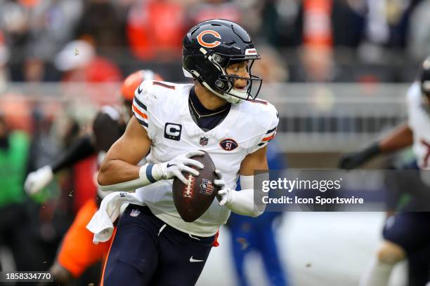 Chicago Bears quarterback Justin Fields rolls out of the pocket during the first quarter of the National Football League game between the Chicago...