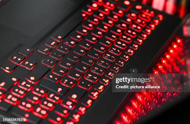 December 2023, Berlin: The keyboard of a laptop lights up red and is reflected on the screen. Photo: Jens Kalaene/dpa