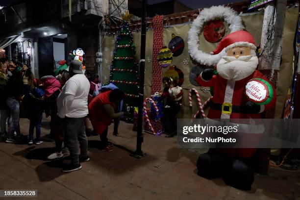 Group of people is waiting to board the new Christmas Train that is circulating in the streets of Santiago Zapotitlan Tlahuac, Mexico City, as part...