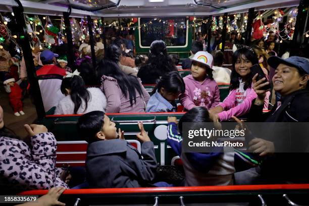 Group of people is boarding the new Christmas Train that is circulating in the streets of Santiago Zapotitlan Tlahuac, Mexico City, as part of the...