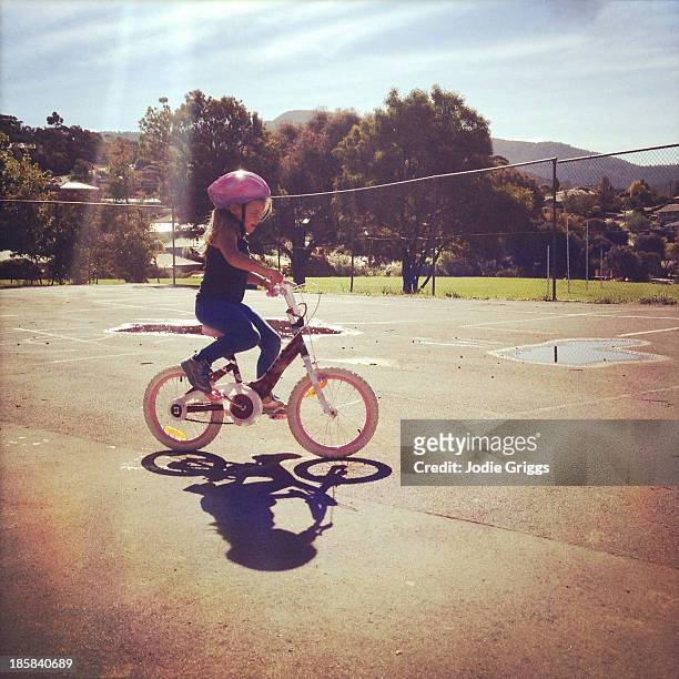 child wearing helmet riding a bike on summer day - girl bike stock pictures, royalty-free photos & images