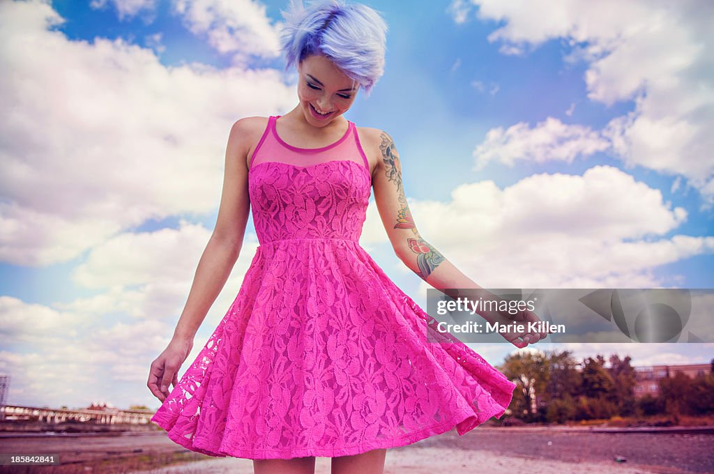 Girl with lavender hair smiling in pink dress