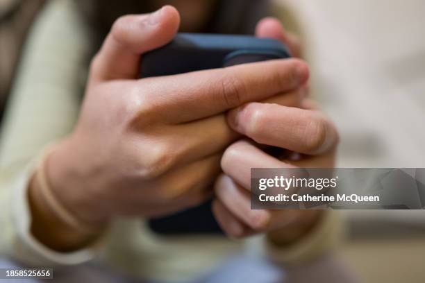 intense: multiracial young woman uses her smart phone - misinformation stock pictures, royalty-free photos & images