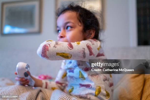 young multiracial girl coughs into her elbow - covid politics stock pictures, royalty-free photos & images