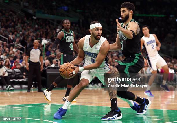 Jayson Tatum of the Boston Celtics defends Jalen Suggs of the Orlando Magic during the first half at TD Garden on December 15, 2023 in Boston,...