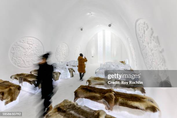 Visitors walk through the ceremony hall at Icehotel 34 on December 15, 2023 in Jukkasjarvi, Sweden. Since 1989, the Icehotel - part hotel, part art...