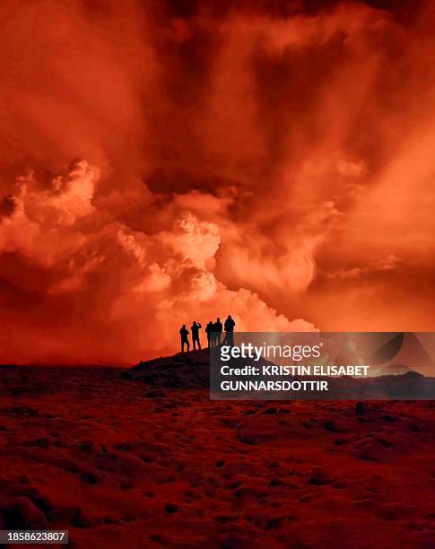 Local resident watch smoke billow as the lava colour the night sky orange from an volcanic eruption on the Reykjanes peninsula 3 km north of...