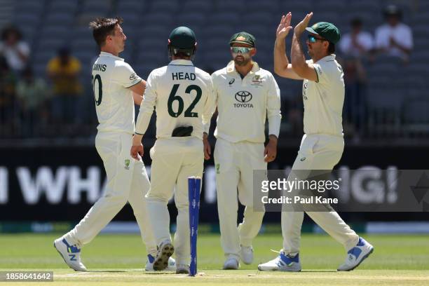 Pat Cummins of Australia celebrates with team mates the wicket of Khurram Shahzad of Pakistan during day three of the Men's First Test match between...