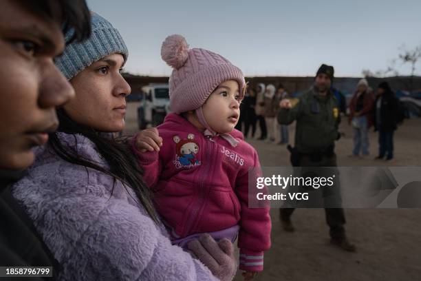 Asylum seeking migrants wait to be processed by the U.S. Border Patrol after crossing from Mexico at a makeshift camp next to the US border wall on...