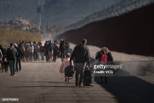 Asylum seeking migrants wait to be processed by the U.S. Border Patrol after crossing from Mexico at a makeshift camp next to the US border wall on...