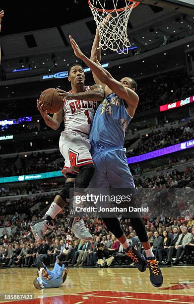 Derrick Rose of the Chicago Bulls goes up for a shot against JaVale McGee of the Denver Nuggets during a preseason game at the United Center on...