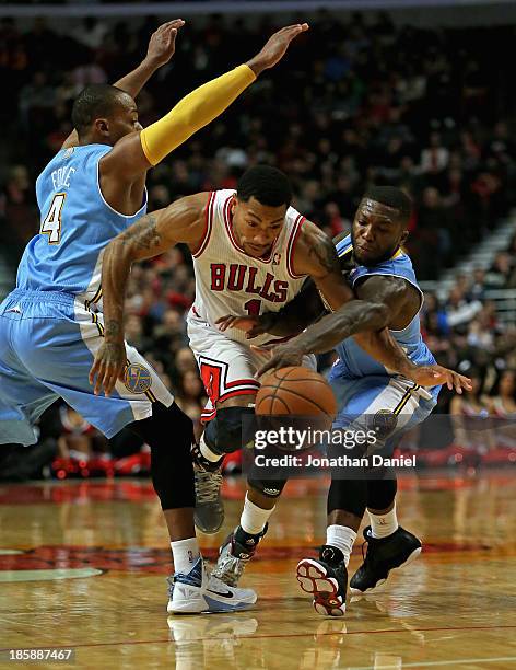 Derrick Rose of the Chicago Bulls is fouled by Nate Robinson of the Denver Nuggets as he drives between Robinson and Randy Foye during a preseason...