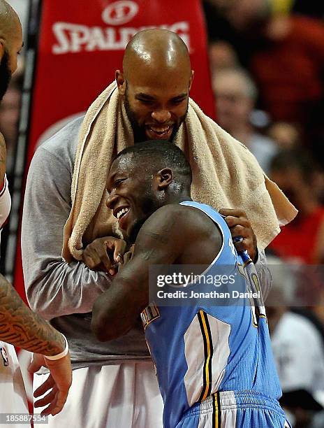 Taj Gibson of the Chicago Bulls and Nate Robinson of the Denver Nuggets share a laugh and a hug after a preseason game at the United Center on...