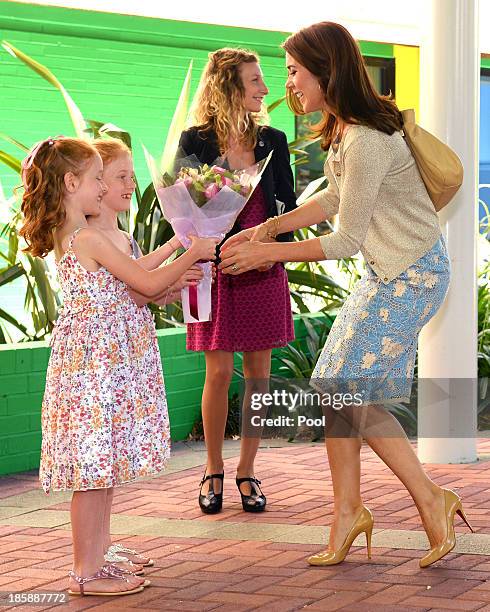 Princess Mary of Denmark receives flowers from identical twins Lillian and Charlotte Harding as the royal couple arrive for a visit to the Australian...