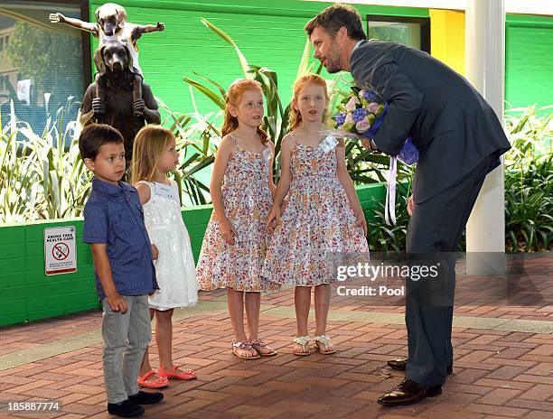 Prince Frederik of Denmark receives flowers from identical twins Lillian and Charlotte Harding as the royal couple arrive for a visit to the...