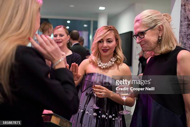 Nasiba Adilova and Cindy Rachofsky discus the new jewelry of Sabine Ghanem during the Young Collectors Two x Two Cocktail party at the Rachofsky...