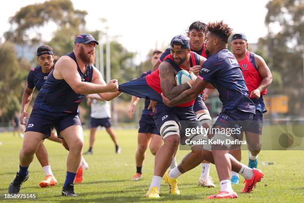 Lukhan Salakaia-Loto of the Rebels is tackled by Cabous Eloff of the Rebels and Judah Saumaisue of the Rebels during a Melbourne Rebels Open Training...