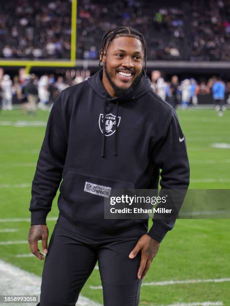 Running back Josh Jacobs of the Las Vegas Raiders smiles on the sideline as his teammates warm up for a game against the Los Angeles Chargers at...