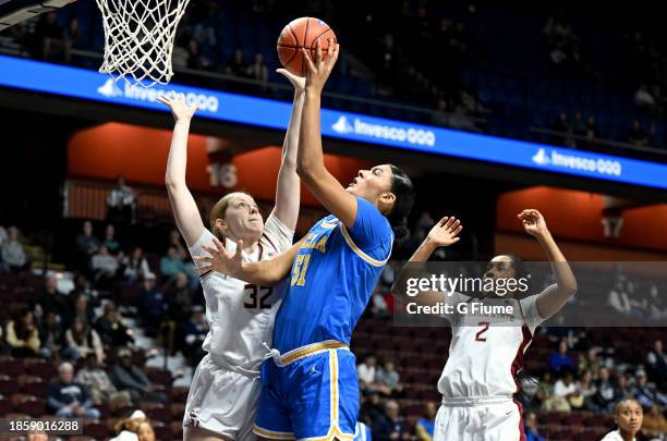 Lauren Betts of the UCLA Bruins shoots the ball against Avery Treadwell and Alexis Tucker of the Florida State Seminoles at Mohegan Sun Arena on...