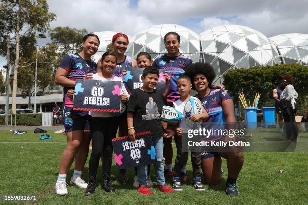 Laiema Bosenavulagi and Sydney Niupulusu of the Rebels and team mates pose with Rebels supporters during a Melbourne Rebels Open Training Session at...