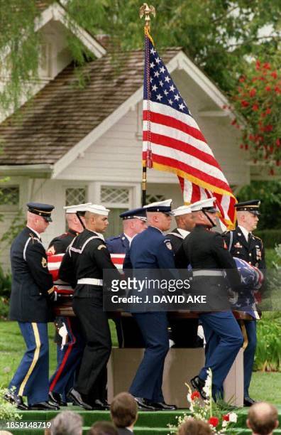 Military honor guard carries former President Richard M. Nixon's flag-draped casket past the house in which he was born, during the late president's...