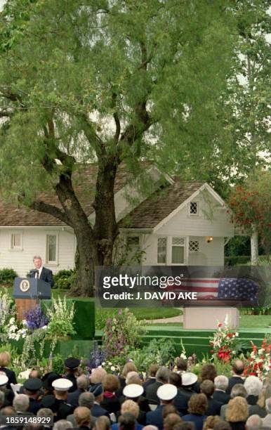 President Bill Clinton stands alongside President Nixon's flag-draped casket which lies infront of the house in which the late US President Richard...