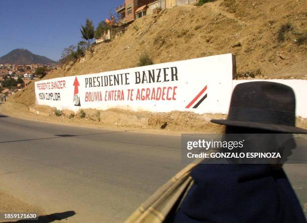 Woman walks by a wall painted with a message thanking the president of Bolivia, Hugo Banzer Suarez, on August 05, 2001 in Sucre, Bolivia. Banzer,...