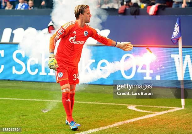 Goalkeeper Timo Hildbrand of Schalke takes a flare from the pitch during the Bundesliga match between FC Schalke 04 and Borussia Dortmund at...
