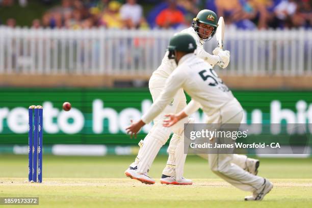 Usman Khawaja of Australia watches the ball after playing a shot during day three of the Men's First Test match between Australia and Pakistan at...