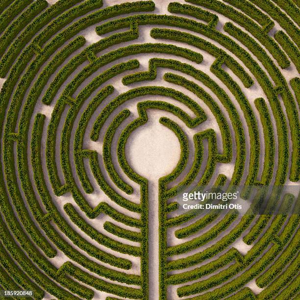 aerial view of circular hedge maze, path to centre - ingewikkeldheid stockfoto's en -beelden